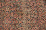 Herati pattern detail on the antique Malayer rug, showing even patina and blush, navy, charcoal hues.