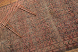 Even distress across an antique Malayer rug's blush and charcoal Herati design.