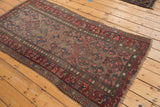 Distressed vintage Kurdish Hamadan rug corner, with geometric leaf motifs and natural fringe.