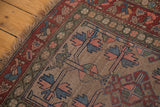 Distressed corner of vintage Kurdish Hamadan rug, geometric tree-of-life, red, blue.