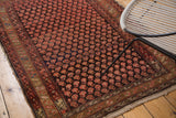 Vintage Persian Hamadan rug corner, cranberry blush boteh motifs, charcoal brown field, tattered edges.