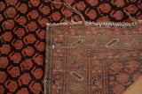 Vintage Persian Hamadan rug showing woven foundation, tattered ends, and madder red pattern.