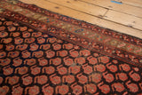 Vintage Hamadan rug detail with tattered ends, revealing a madder root red border and cranberry blush boteh pattern.