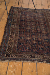 Tattered fringe and geometric border of the distressed vintage Belouch rug.