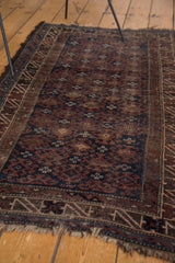 Distressed geometric border and tattered fringe on a vintage Belouch rug.