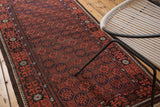 Vintage Afghan rug with repeating gul motif, crab border, and original goat hair selvage.
