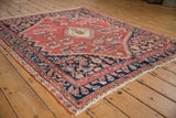 Cinnabar red field with unusual isolated Herati motifs, charcoal border, distressed texture.