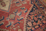 Distressed cinnabar red, charcoal patterns with visible foundation on a Malayer rug.