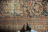 Antique Mustafi Mahal carpet, worn indigo field with peach scrolling vines and geometric border.
