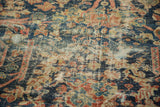 Antique Mustafi Mahal rug detail: worn pile, visible foundation, navy and terra cotta motifs.