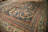 Corner detail of antique Mustafi Mahal rug showing navy blue field and terra cotta floral borders.