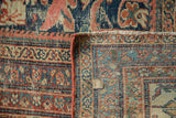 Antique Mustafi Mahal rug's worn floral pile, secured terra cotta binding, hand-knotted foundation.