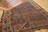 Distressed antique Kamseh rug, worn indigo field, stylized tree motifs, tattered edge.