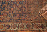 Detail of antique Kamseh rug's complex tribal border, showing indigo field and textural patina.