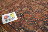 Close-up of hand-knotted Antique Kamseh rug, tribal plant and animal motifs in indigo and madder.
