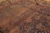 Visible hard distress and wear on an antique Kamseh rug, showcasing muted red and indigo blue.