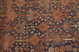 Distressed indigo blue ground of the antique Kamseh rug with repeating animal and plant motifs.