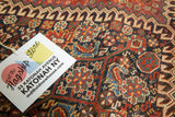 Antique Persian Qashqai rug close-up showing intricate, traditional allover pattern in madder red and indigo blue, with even pile wear.