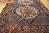 Vintage Afshar rug showing concentric geometric patterns in sky blue, indigo, and madder rust.