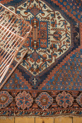 Terra cotta geometric border, intricate blue field, and natural fringe of Afshar rug.