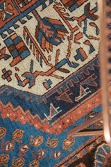 Vintage Afshar rug's geometric concentric field with repeating boteh in sky blue, madder root, indigo.