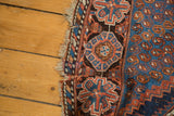 Blue and terracotta geometric border with repeating boteh motif on the Afshar rug.