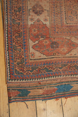 Antique Afshar rug corner: madder red and sky blue geometric border, visible kilim tatter.
