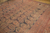 Distressed pile of antique Afshar carpet, showing oversized madder red paisley boteh and patterned border.