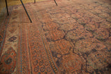 Oversized paisley boteh on a distressed madder red field with a tribal patterned border.