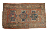 Antique Persian Soumac carpet, triple navy starburst medallions on a terra cotta field.