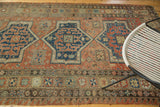 Rectilinear field and pomegranate border of antique Soumac carpet with etched dark shades.