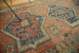 Antique Persian Soumac carpet showing intricate starburst motifs in navy, terra cotta.