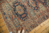 Oblong and octagonal medallions, navy blue, pomegranate red, ivory on antique Soumac rug.