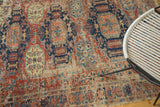 Patina on geometric octagonal patterns in navy, red, and ivory of the antique Soumac rug.