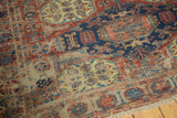 Antique Soumac rug's geometric medallions, visible weave, time-softened red, blue, ivory, and fringe.