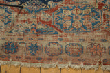 Frayed edge, exposed foundation, and geometric patterns in red, blue, and ivory on antique Soumac.