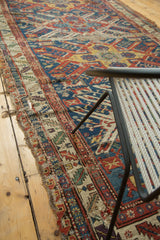 Geometric border of antique Soumac runner, with tattered edge and vivid gem-tone patterns.