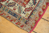 Antique Persian Soumac rug runner's tattered edge reveals foundation and gem-tone patterns.