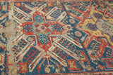 Worn geometric pattern on an antique Soumac rug, revealing foundation in navy, red, yellow.