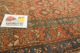 Hand-knotted antique Hamadan rug section with terra cotta, teal geometric patterns, visible wear.