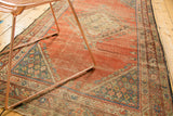 Antique Persian Fereghan rug showing worn field texture and intricate floral border.