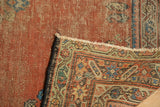 Hand knotted antique Fereghan rug corner detail, showing traditional borders and worn reddish field with visible foundation.