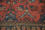 Vintage Lilihan rug detail: cinnabar red field, blue serrated leaves, and a textured border.