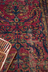 Distressed vintage Lilihan rug field, with navy, gold budding plants.
