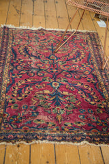 Tattered fringe and distressed raspberry field of a traditional Persian Lilihan rug.