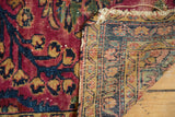 Distressed raspberry red pile and fine woven foundation of a vintage Lilihan rug.