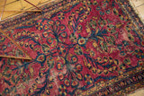 Vintage Lilihan rug's raspberry red field with rich navy blue floral motifs and soft patina.