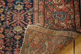 Antique Fereghan rug's rich indigo and madder red floral pile revealing its hand-knotted foundation.