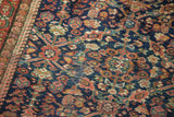 Intricate floral lattice on antique Fereghan rug's indigo field, madder root red, pale rose, localized foundation.
