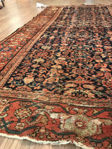 Intricate floral motifs, storied wear, and exposed foundation along the antique Fereghan rug's edge.